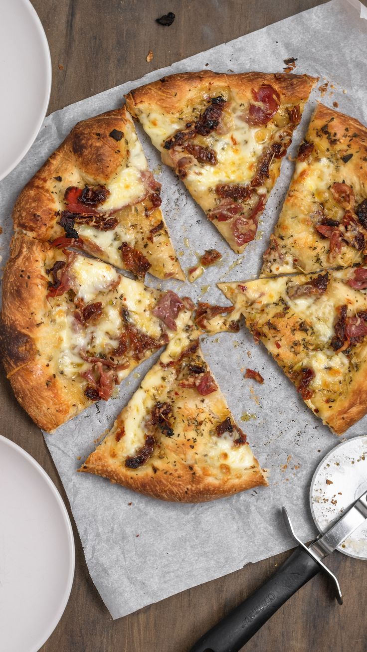 a pizza sitting on top of a pan covered in cheese and toppings next to a spatula