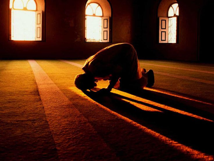 a person kneeling down on the floor in front of two windows with bright light coming through them