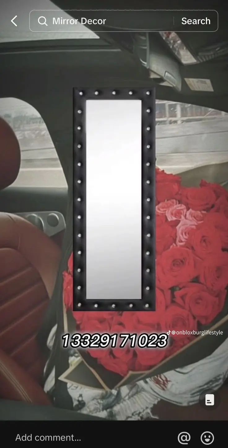 a mirror sitting on top of a car seat next to a pile of red roses