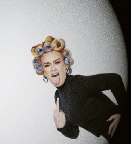 an image of a woman with curlers on her head making a funny face and holding up two fingers