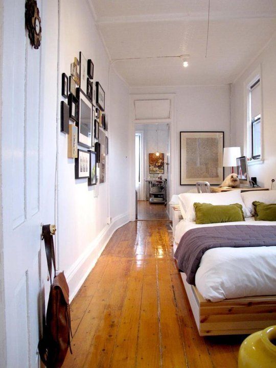 a bedroom with hardwood floors and white walls