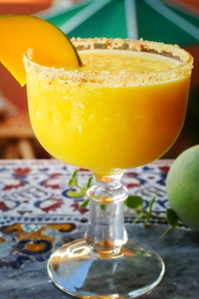 an orange margarita sitting on top of a table