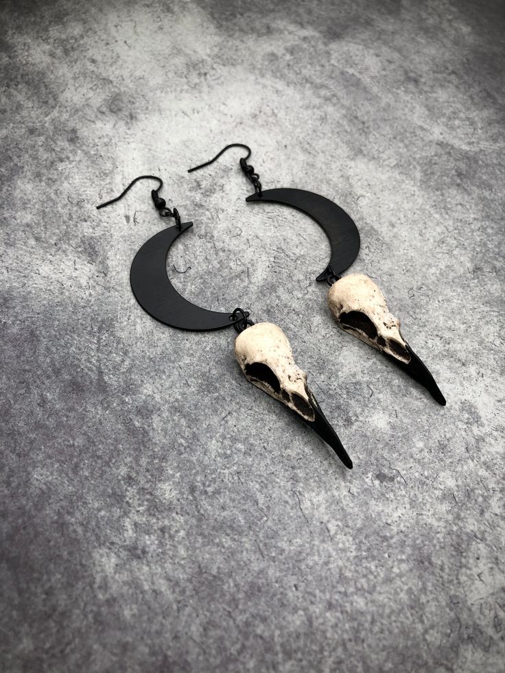 This unique lunar bird skull necklace and earring set is the perfect witchy gift set if you are looking for one of a kind accessories to celebrate bone jewelry, lunar phases, oddities, the occult, witchcraft, alchemy, alternative fashion and goth style. The little mini 1.5” resin raven skulls are hung from perfectly black enamel painted crescent moon charms. In creating this set I wanted to use my top selling mini size raven skull to maintain my style of making resin faux bone jewelry, but then Bird Skull Necklace, Moon Phase Jewelry, Celestial Goddess, Raven Skull Necklace, Witchy Earrings, Lunar Jewelry, Raven Jewelry, Waning Moon, Crescent Moon Jewelry