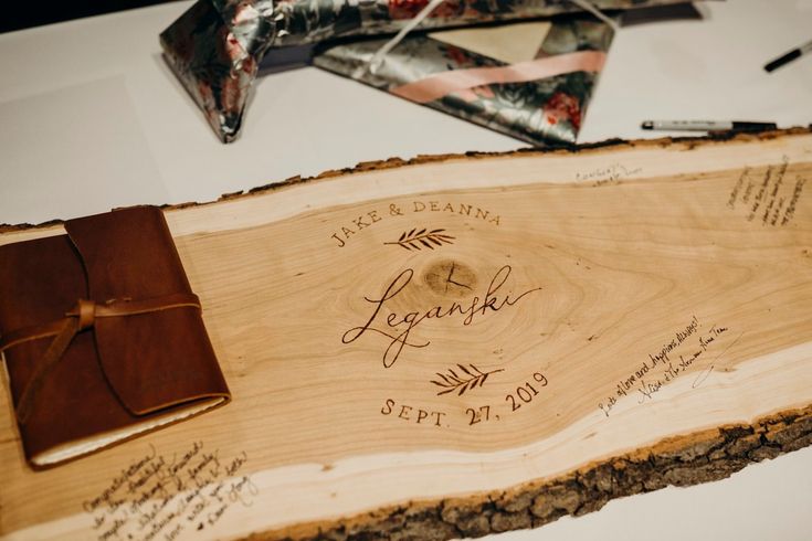 a piece of wood with writing on it and a note pad next to it, along with other items