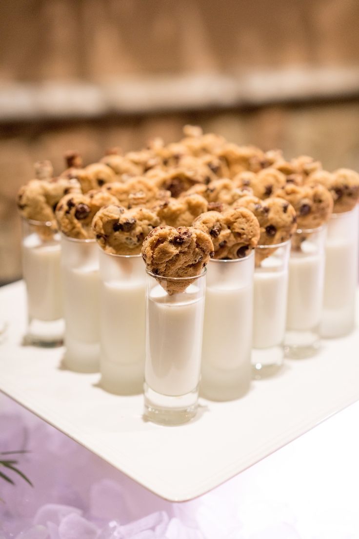 desserts are arranged in small cups on a white tray