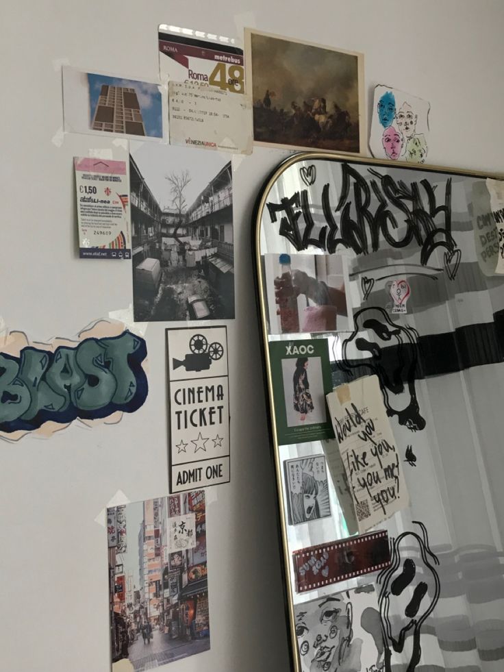 a mirror that is covered in stickers on the side of a wall with graffiti written on it