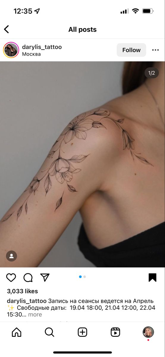 the back of a woman's shoulder with flowers on it and an arrow in the middle