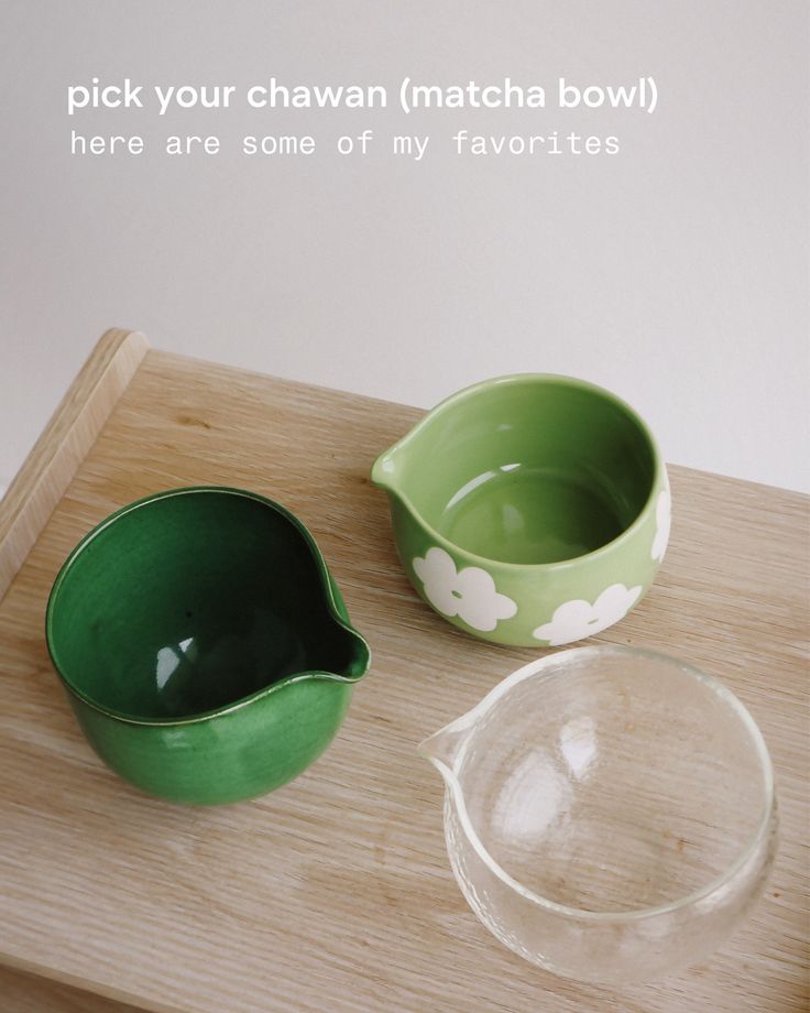 two green bowls sitting on top of a wooden table