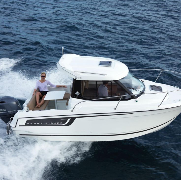 a man riding on the back of a white boat