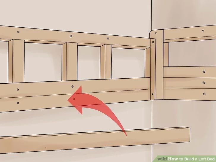 a wooden bed frame with a red arrow pointing to the bottom and side rails on it