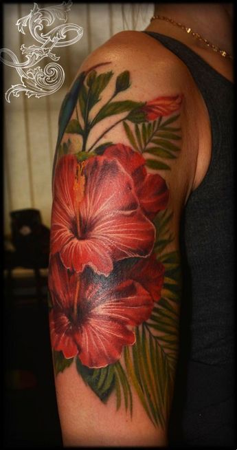 a woman's arm with flowers and leaves painted on the upper half of it