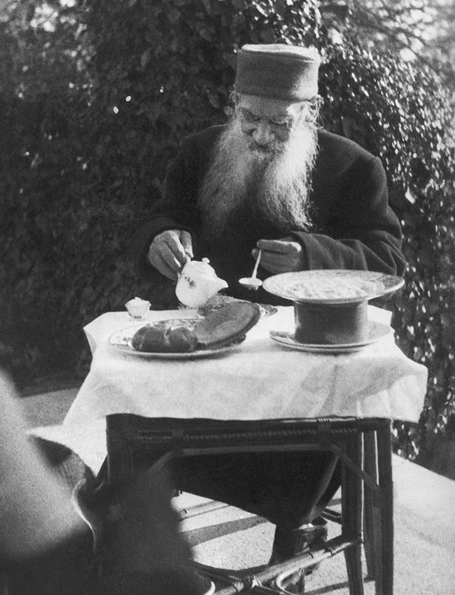 an old man sitting at a table eating food