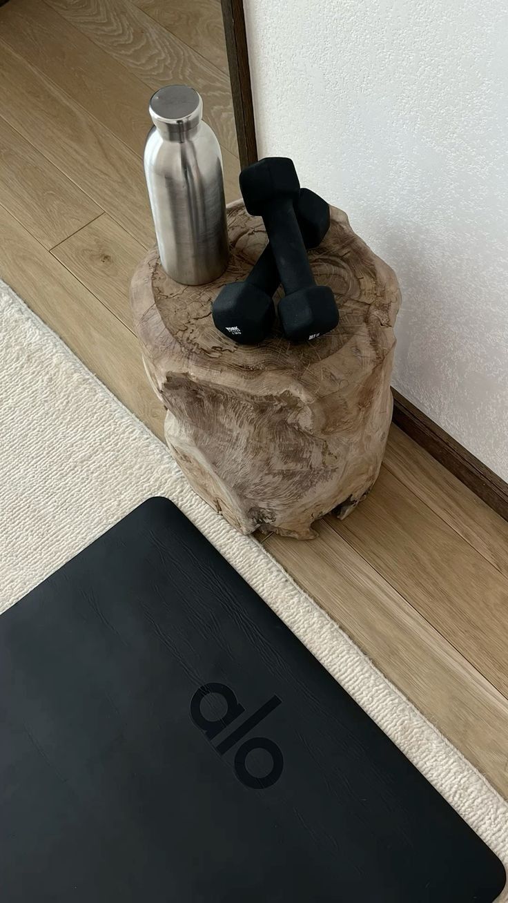 a black object sitting on top of a wooden stump next to a metal bottle opener