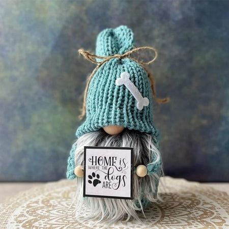 a knitted doll with a sign that says home is where the dogs are on it