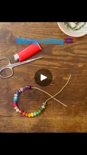 the video shows how to make beaded bracelets with beads and scissors on a wooden table