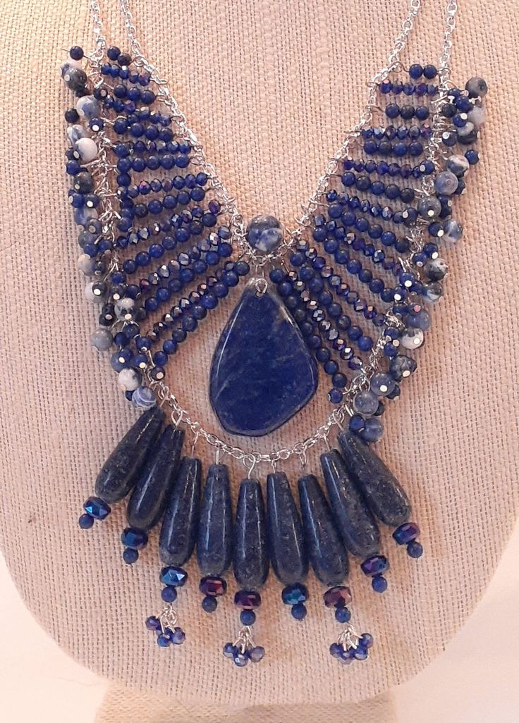 Lapis Lazuli & Sodalite Statement Necklace. This necklace is an absolute statement in beauty, sparkle, and shine! Wear it everyday or on special occasions. This necklace is a one of a kind. Lapis Lazuli is a protection stone. Lapis is also known to help with strength, courage, wisdom, and truth. Sodalite helps with self-esteem, self acceptance, and trust. It also helps in emotional balance. This necklace has a large Lapis Lazuli bead as a center piece surrounded by smaller beads of  Lapis lazuli Blue Kyanite Gemstone Bead Necklaces, Blue Kyanite Gemstone Beaded Necklace, Handmade Sapphire Kyanite Necklace, Handmade Sapphire Necklace In Kyanite, Handmade Blue Sodalite Necklaces, Blue Lapis Lazuli Jewelry, Artisan Blue Jewelry For Party, Blue Lapis Lazuli Necklaces With Stones, Blue Lapis Lazuli Necklace With Stones