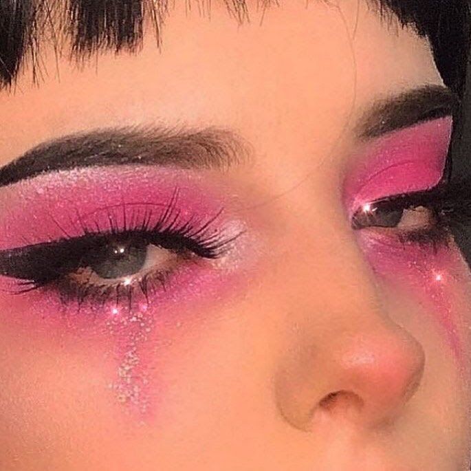 a close up of a woman's face with pink makeup