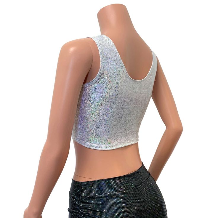 Silver on white holographic ring front crop top for your festival or rave outfit. This sleeveless crop top fits snug to the body and sits above the belly button with a metal ring detail in front. Pair with your favorite high waist skater skirt or holographic cheeky for the perfect rave set. Sleeveless Silver Crop Top For Club, Stretch Silver Crop Top For Summer, Silver Stretch Crop Top For Summer, Summer Disco Metallic Crop Top, Fitted White Rave Tops, Sleeveless Rave Crop Top For Festival, White Cropped Tank Top For Party, Metallic Fitted Trendy Crop Top, Trendy Fitted Metallic Crop Top