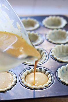 someone pouring batter into a muffin tin