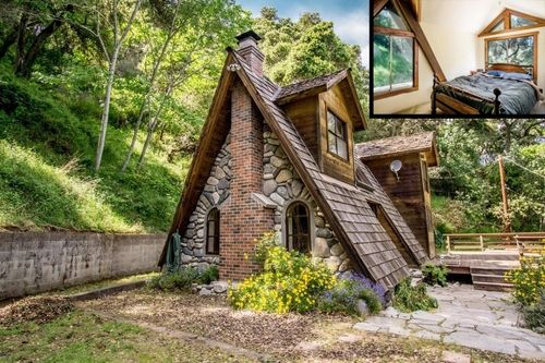 a small house made out of rocks in the woods