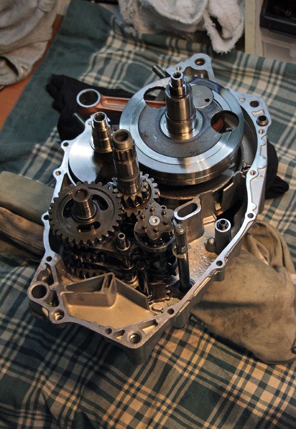 an engine is sitting on top of a plaid cloth and it's gears are still attached to the cylinder