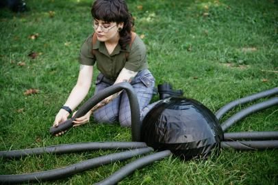 a woman sitting on the ground with some hoses in front of her