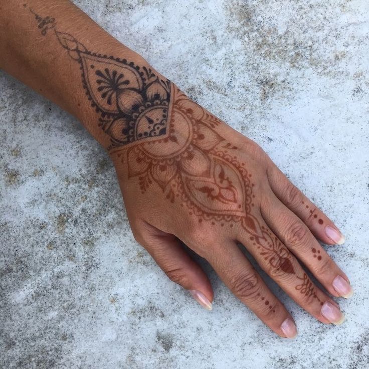 a woman's hand with henna tattoos on it