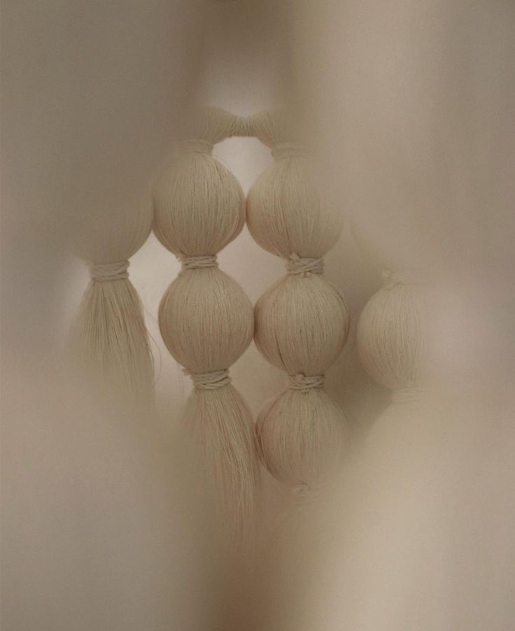 a group of white balls with tassels hanging from the ceiling in a room