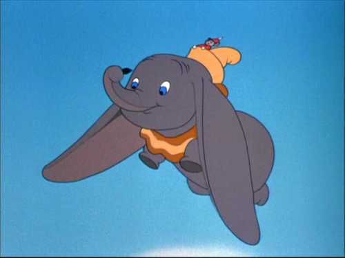 an elephant flying through the air with a person on its back