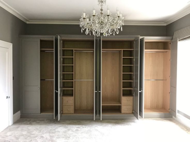 an empty room with closets and chandelier