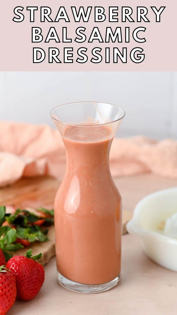 strawberry balsamic dressing in a glass bottle next to strawberries