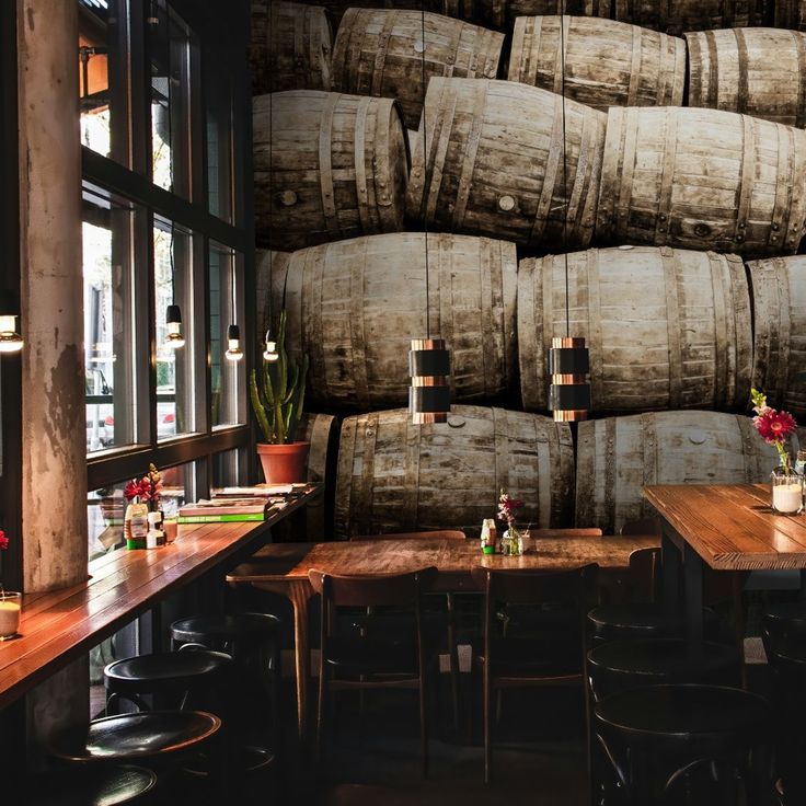 a large stack of barrels sitting on top of a wooden table next to a window