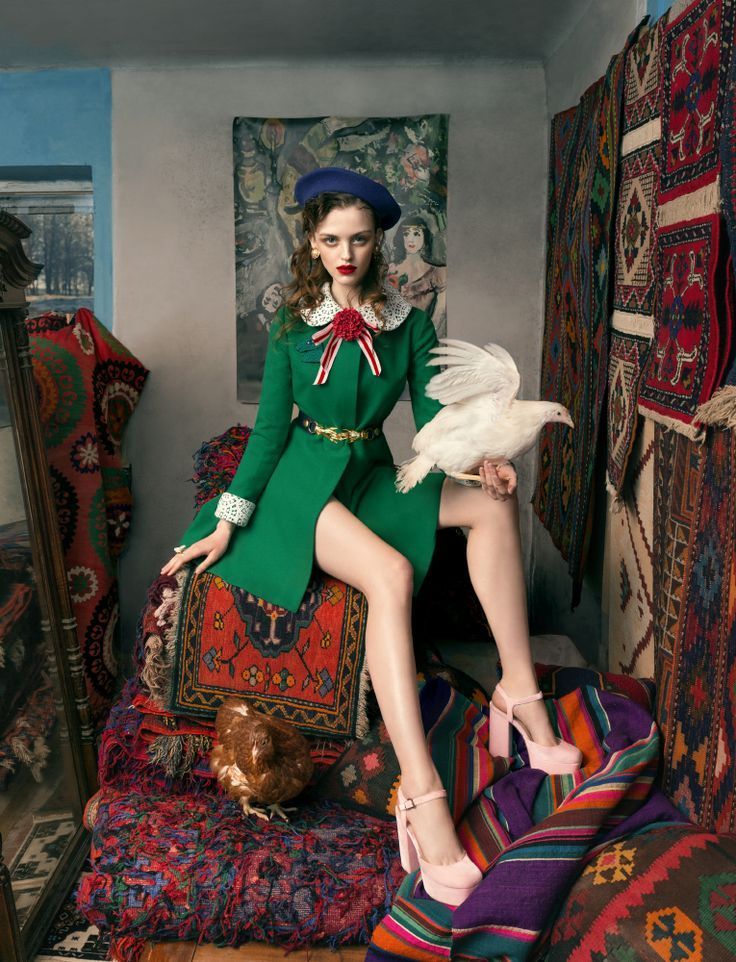 a woman sitting on top of a bed in a room filled with rugs and blankets