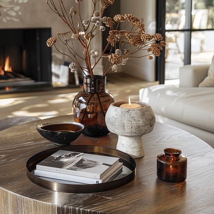 a living room with a coffee table, vase and candles