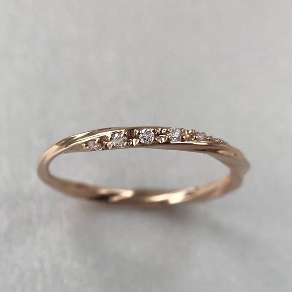 a gold wedding band with five diamonds