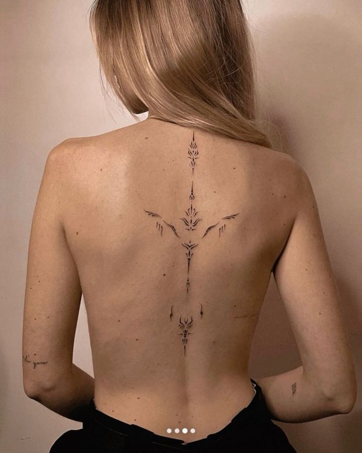 a woman with a cross tattoo on her back