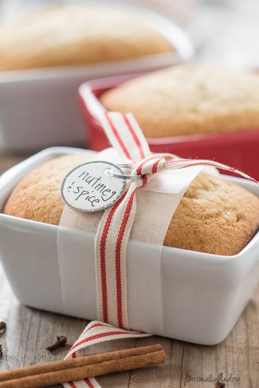 a close up of a loaf of bread in a pan with cinnamon sticks on the side