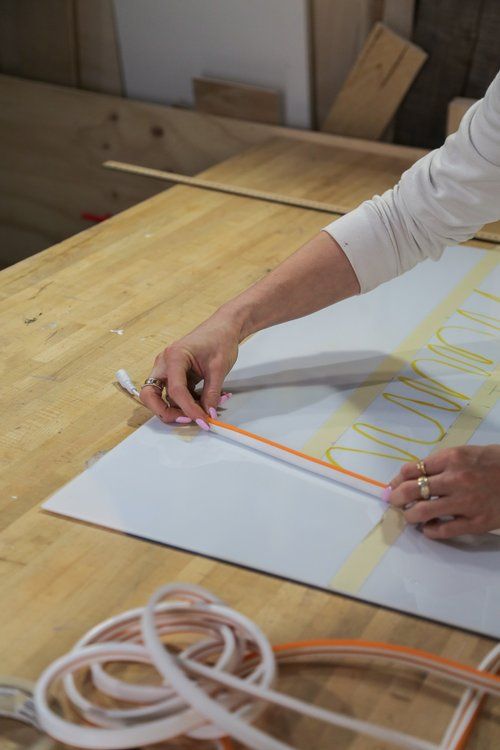 a woman is working on some type of art project with scissors and tape in her hands