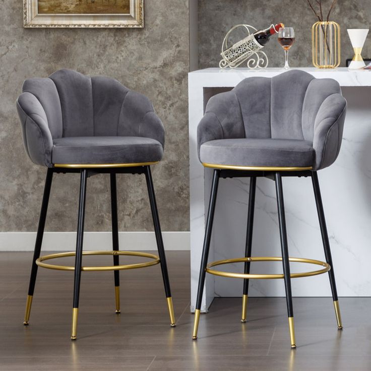 two grey velvet bar stools with gold accents