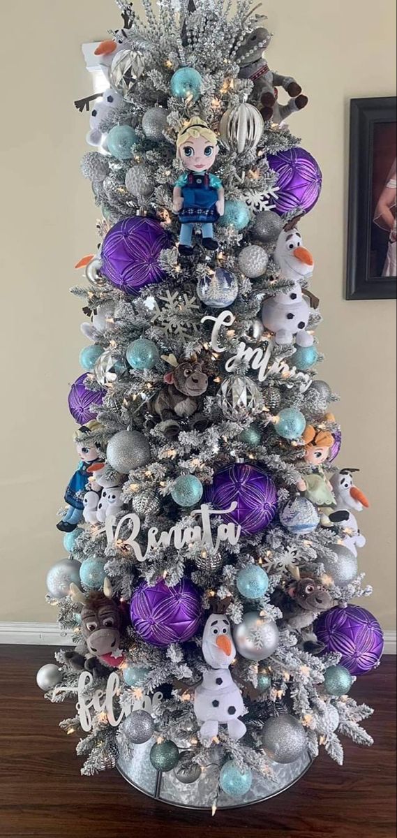 a silver christmas tree with purple and blue ornaments