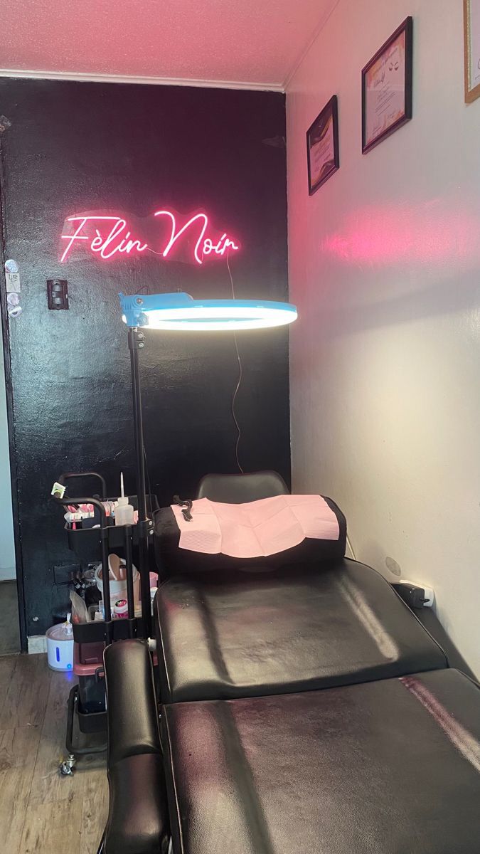 a room with a bed and neon sign on the wall