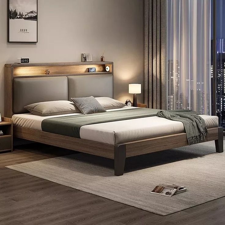 a bedroom with a bed, night stand and large window overlooking the city at night