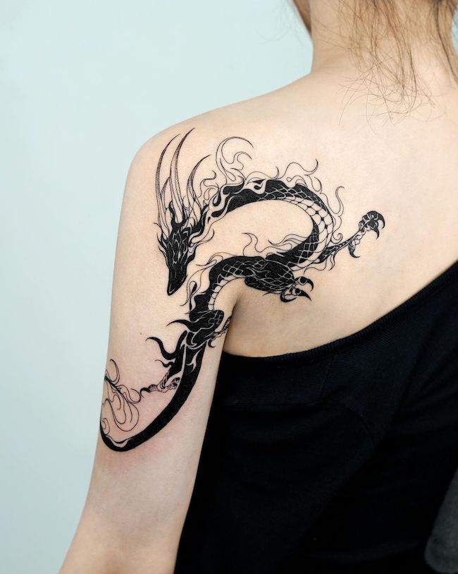 a woman with a dragon tattoo on her shoulder