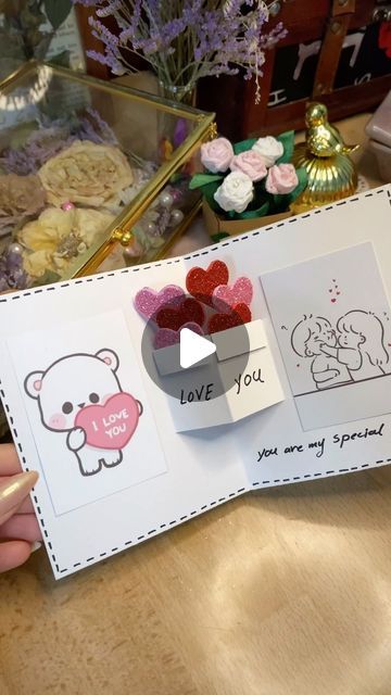 someone is holding up a valentine's day card with hearts and bears on it