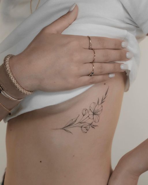 a woman's stomach with flowers on it and her hand resting on the side