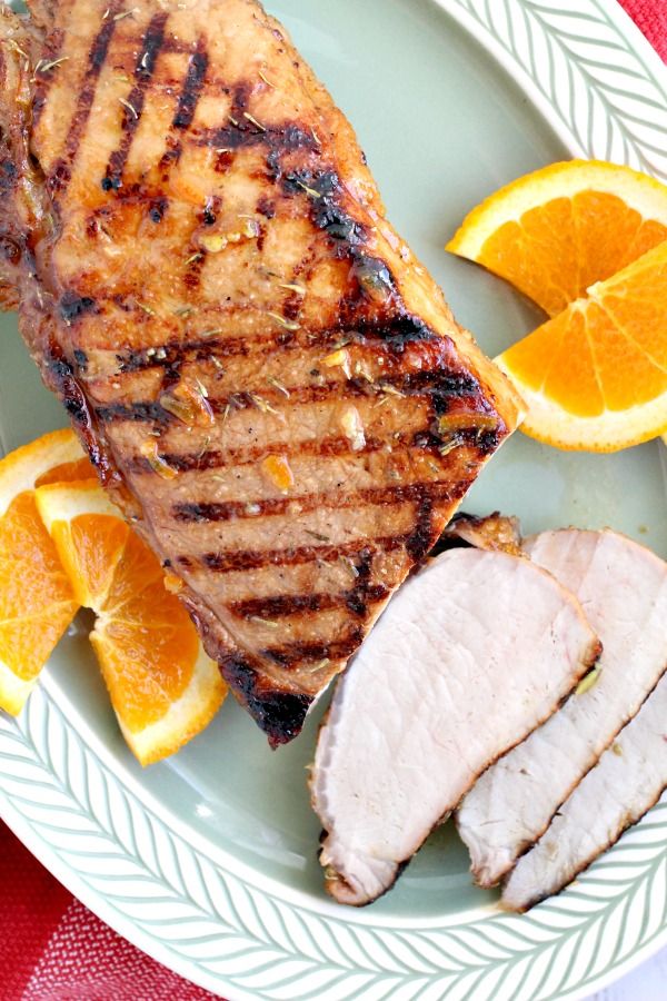 grilled meat and sliced oranges on a plate