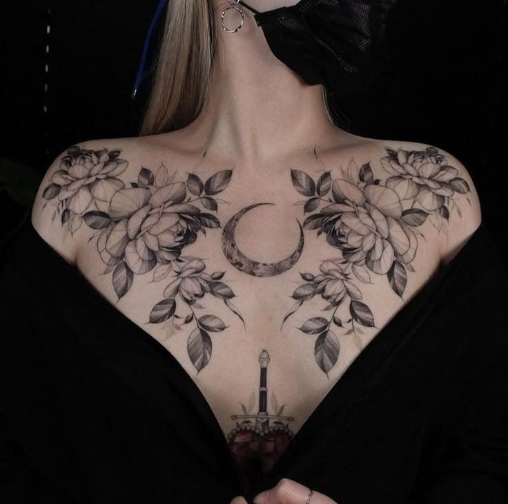 a woman with tattoos on her chest wearing a black mask and bow in front of her face