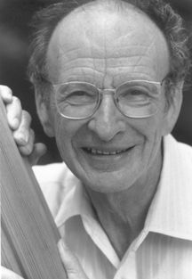 black and white photograph of an older man holding a baseball bat in his right hand