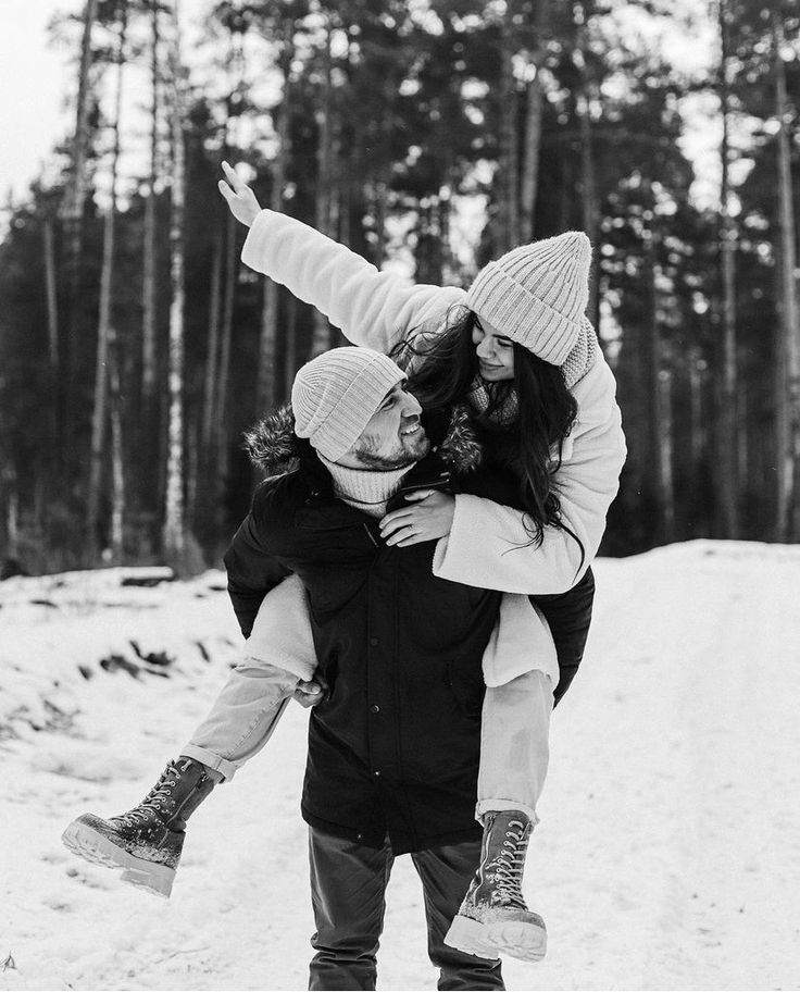 black and white photograph of two girls playing in the snow with their arms around each other