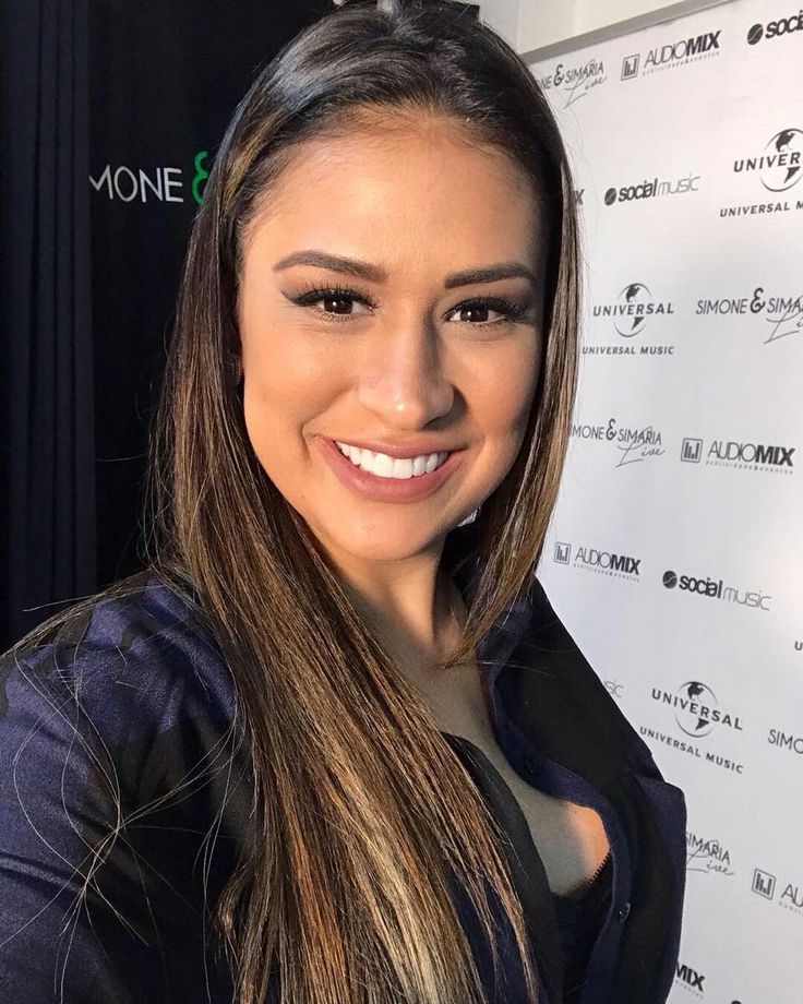 a woman with long hair smiling at the camera